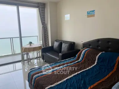 Spacious bedroom with ocean view and balcony access in modern apartment