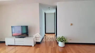 Spacious living room with wooden flooring and modern TV setup