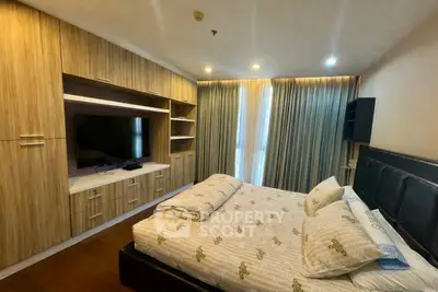 Modern bedroom with built-in wooden wardrobe and large TV