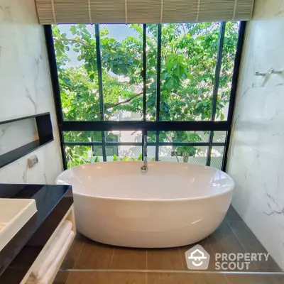 Luxurious bathroom with freestanding bathtub and large window view