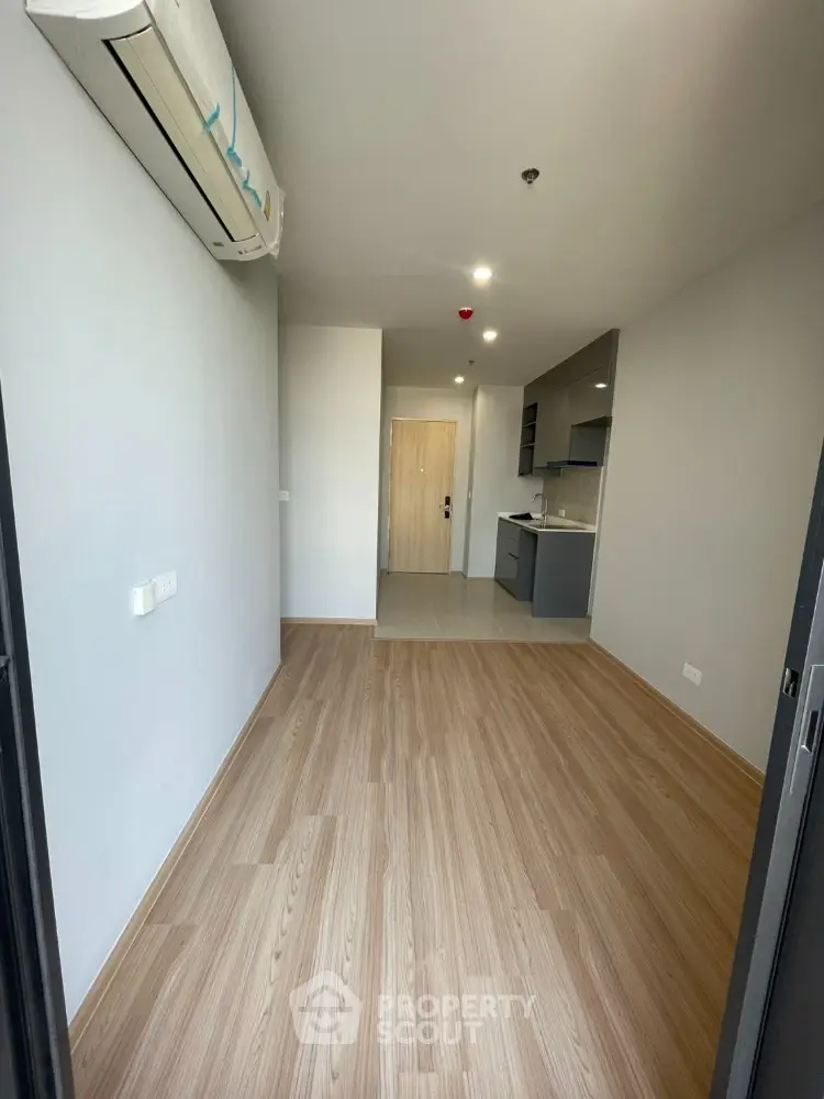 Modern apartment interior with wooden flooring and compact kitchen