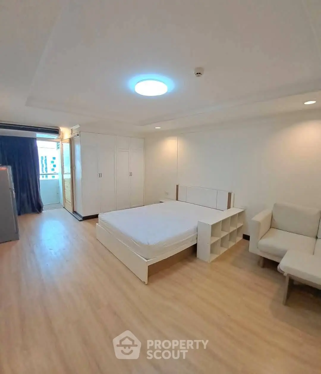 Spacious bedroom with modern furnishings and ample natural light in a stylish apartment.