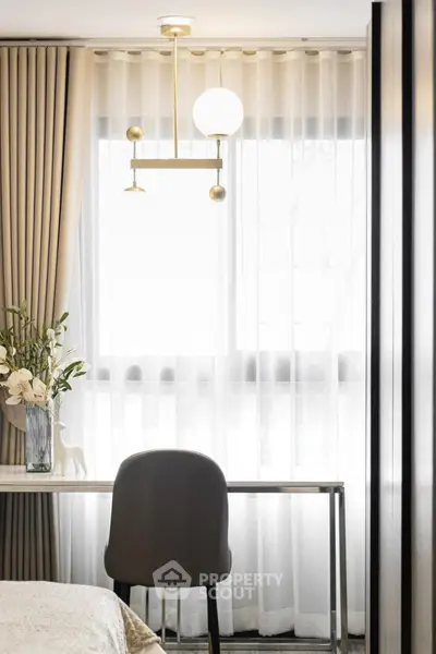 Elegant study area with modern desk and chair, soft lighting, and decorative curtains.