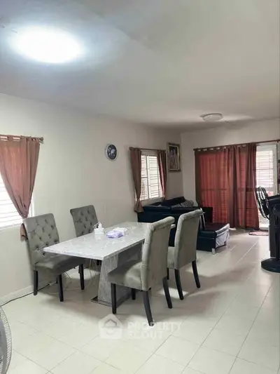 Spacious living room with dining area and elegant furniture in a cozy home setting.