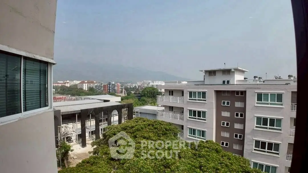 Stunning cityscape view from modern apartment building with lush greenery.