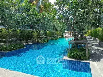 Luxurious outdoor pool surrounded by lush greenery in a modern residential complex.