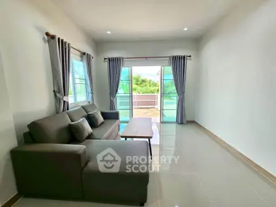 Spacious living room with modern sofa and large windows offering scenic views.