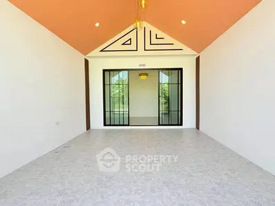 Spacious modern room with high ceiling and large glass doors