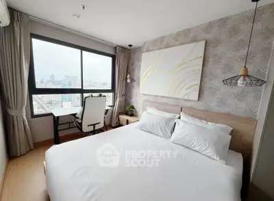 Modern bedroom with city view, featuring stylish decor and a cozy workspace by the window.
