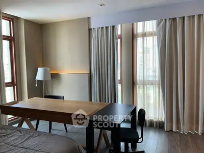 Modern bedroom with large windows and stylish wooden desk