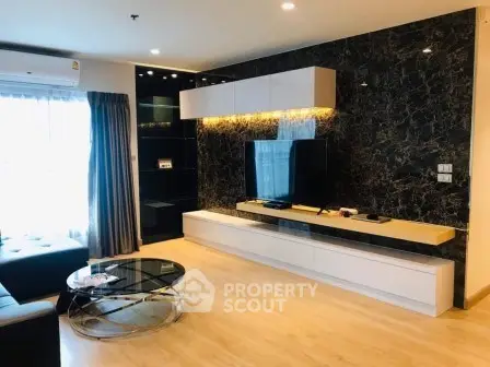 Modern living room with sleek design, marble accent wall, and natural light.