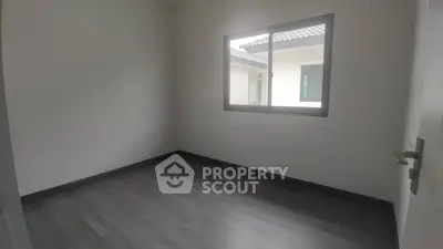 Spacious empty room with large window and modern flooring
