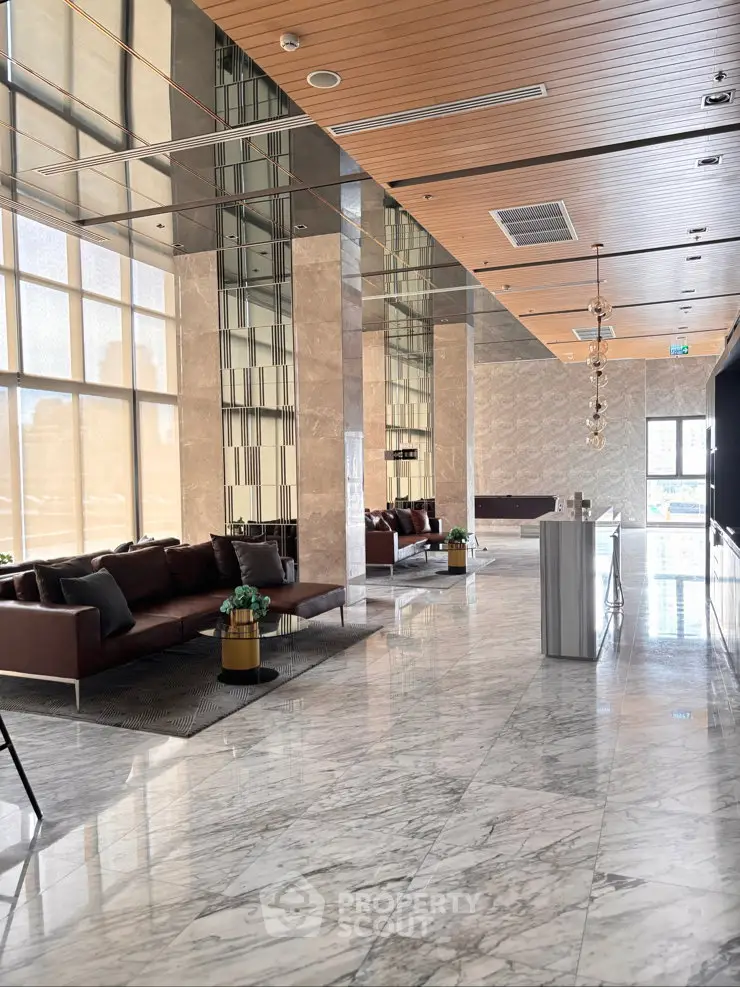 Luxurious modern lobby with marble floors and elegant seating area in high-end building.