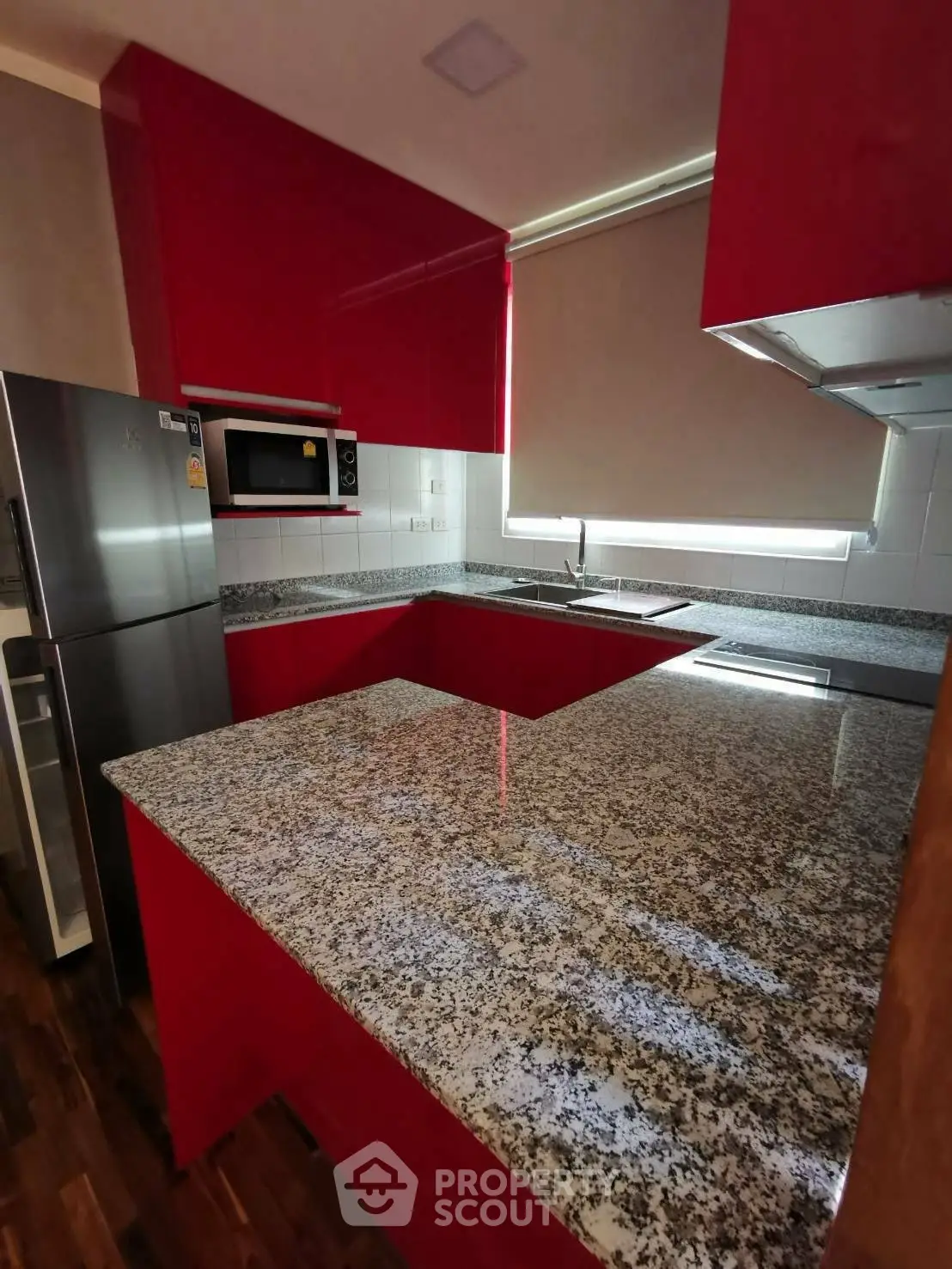 Modern kitchen with red cabinetry and granite countertops