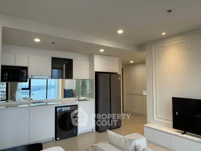 Modern open-plan kitchen and living room with sleek appliances and a stunning view.