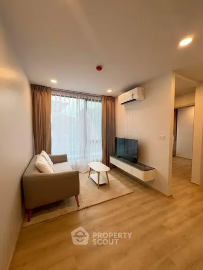 Modern living room with cozy sofa, TV, and large window in stylish apartment.