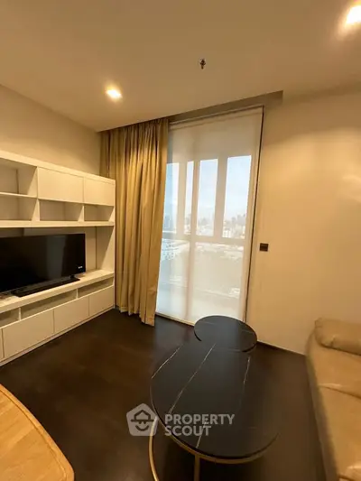 Modern living room with city view, featuring sleek furniture and large window for natural light.