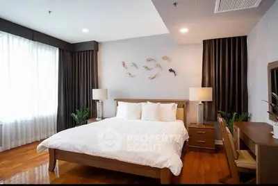 Spacious bedroom with elegant decor and natural light, perfect for relaxation.