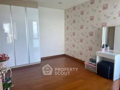 Spacious bedroom with elegant wallpaper and wooden flooring