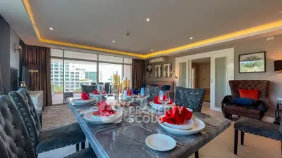 Luxurious dining area with elegant table setting and spacious living room view.
