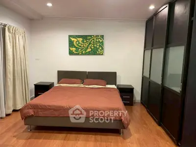 Spacious bedroom with modern decor and hardwood flooring