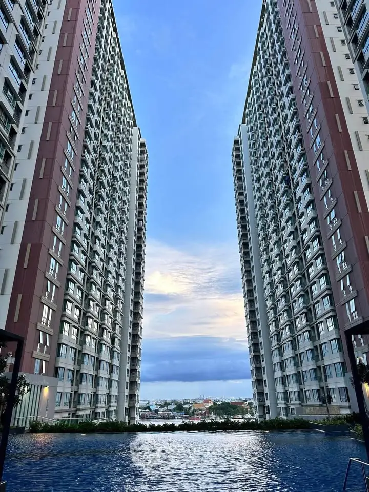 Stunning high-rise residential buildings with a serene pool and breathtaking city view.