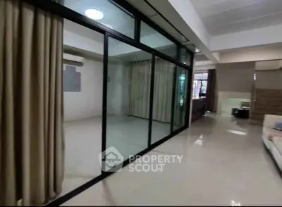 Spacious modern living room with glass partition and elegant curtains