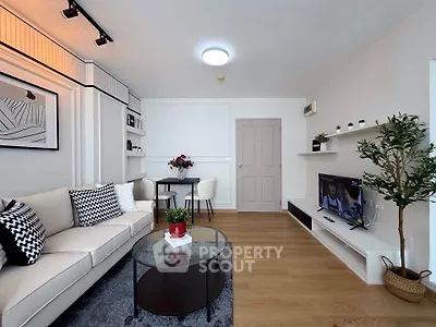 Modern living room with stylish decor, cozy seating, and wall-mounted TV, perfect for relaxation and entertainment.