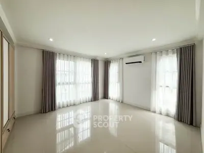 Spacious corner unit living room with large windows and modern air conditioning.