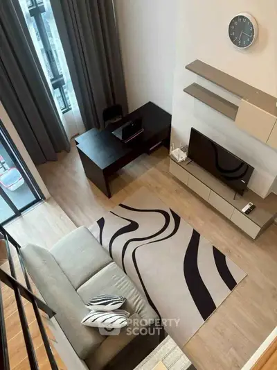Modern living room with stylish decor, featuring a cozy sofa, sleek desk, and wall-mounted TV, perfect for urban living.