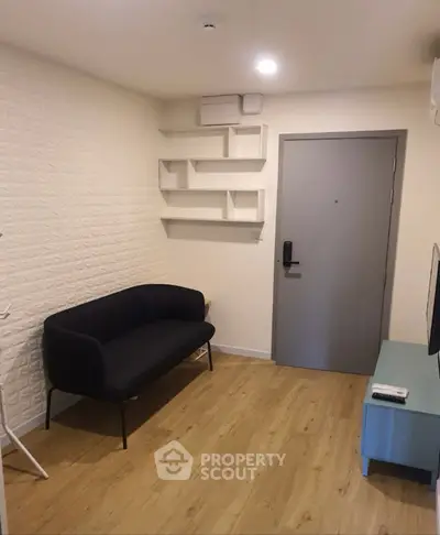 Cozy living room with modern sofa and wall-mounted shelves, perfect for urban living.