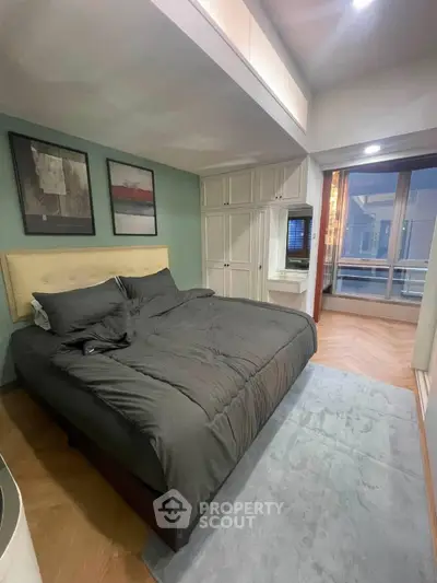 Modern bedroom with stylish decor and large window offering natural light
