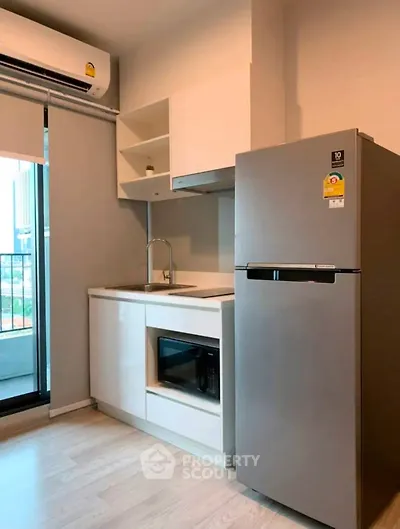 Modern kitchen with sleek appliances and balcony view in urban apartment