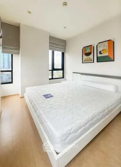 Modern bedroom with large windows and stylish decor in a high-rise apartment.