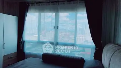 Spacious bedroom with large window offering stunning city views.