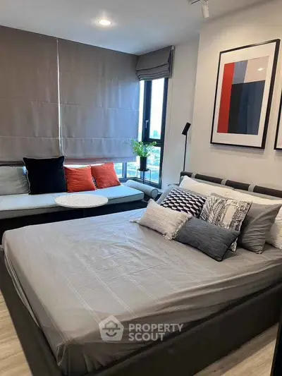 Modern bedroom with stylish decor and cozy seating area, perfect for relaxation and comfort.