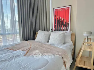 Modern bedroom with stylish decor and large window offering city views.