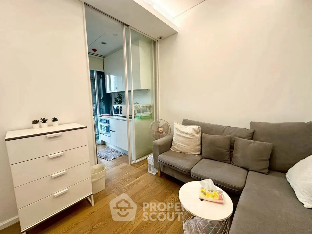 Cozy living room with modern decor and open kitchen layout in a stylish apartment.