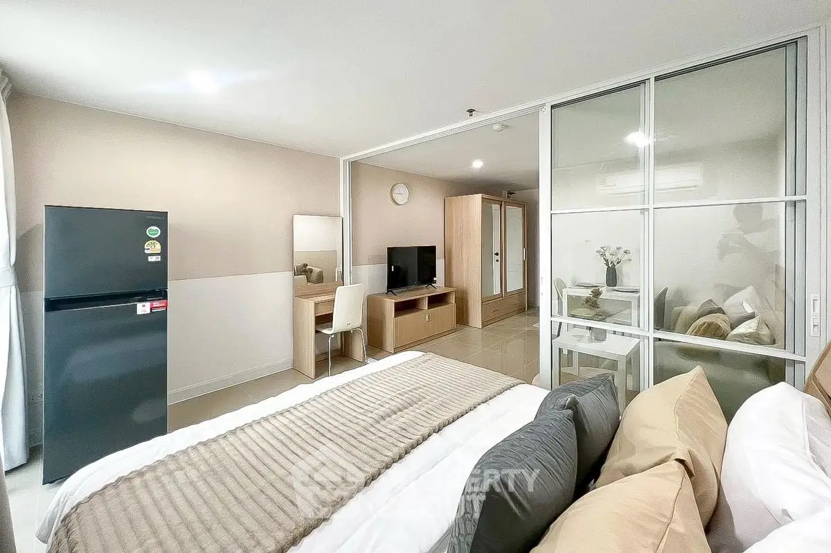 Modern bedroom with stylish decor and open layout featuring a cozy dining area and sleek appliances.