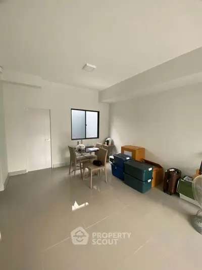 Spacious living room with modern decor and ample natural light, perfect for comfortable living.