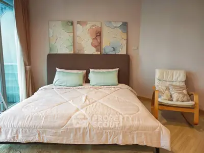Cozy bedroom with stylish decor and natural light, featuring a comfortable bed and modern chair.
