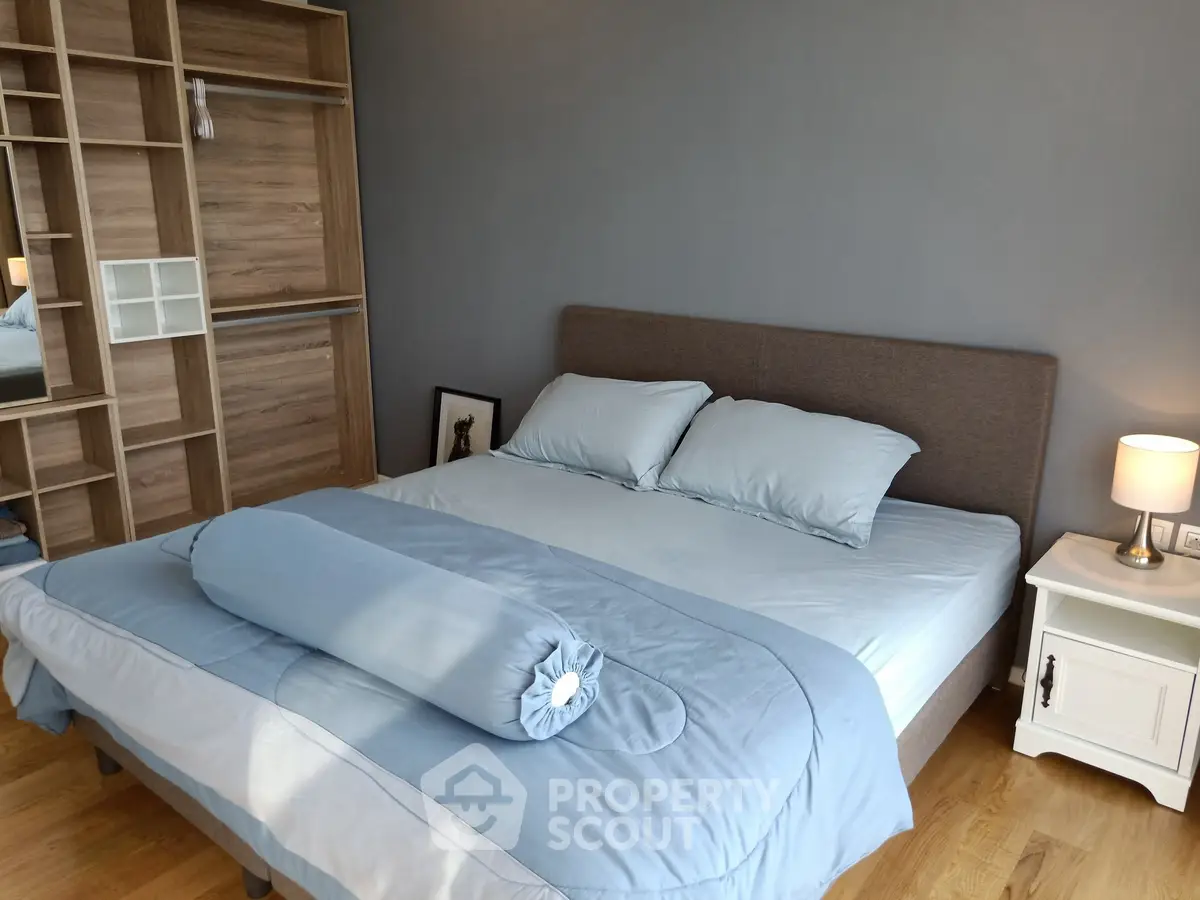 Cozy bedroom with modern design, featuring a stylish bed and elegant wooden shelving.