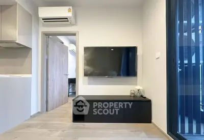 Modern living room with sleek TV setup and air conditioning in a stylish apartment.