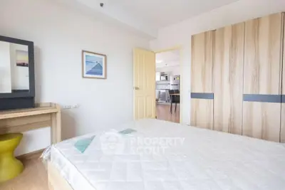 Spacious bedroom with modern decor and ample natural light in a stylish apartment.