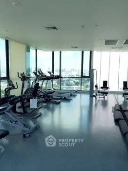 Spacious gym with city view and modern fitness equipment