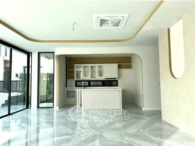 Modern kitchen with sleek design and marble flooring, featuring large windows and open layout.