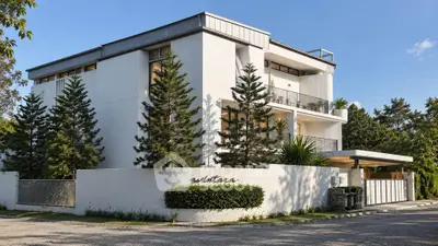 Modern luxury building with sleek design and lush greenery, perfect for upscale living.