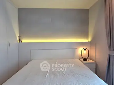 Modern minimalist bedroom with ambient lighting and sleek furniture design.