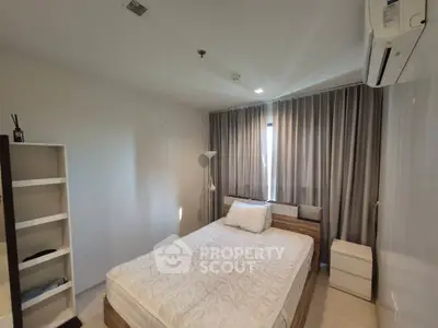 Modern bedroom with natural light, featuring a stylish bed and minimalist decor.