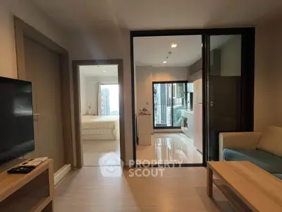 Modern apartment interior with open layout, featuring a cozy living room and a glimpse of the bedroom.